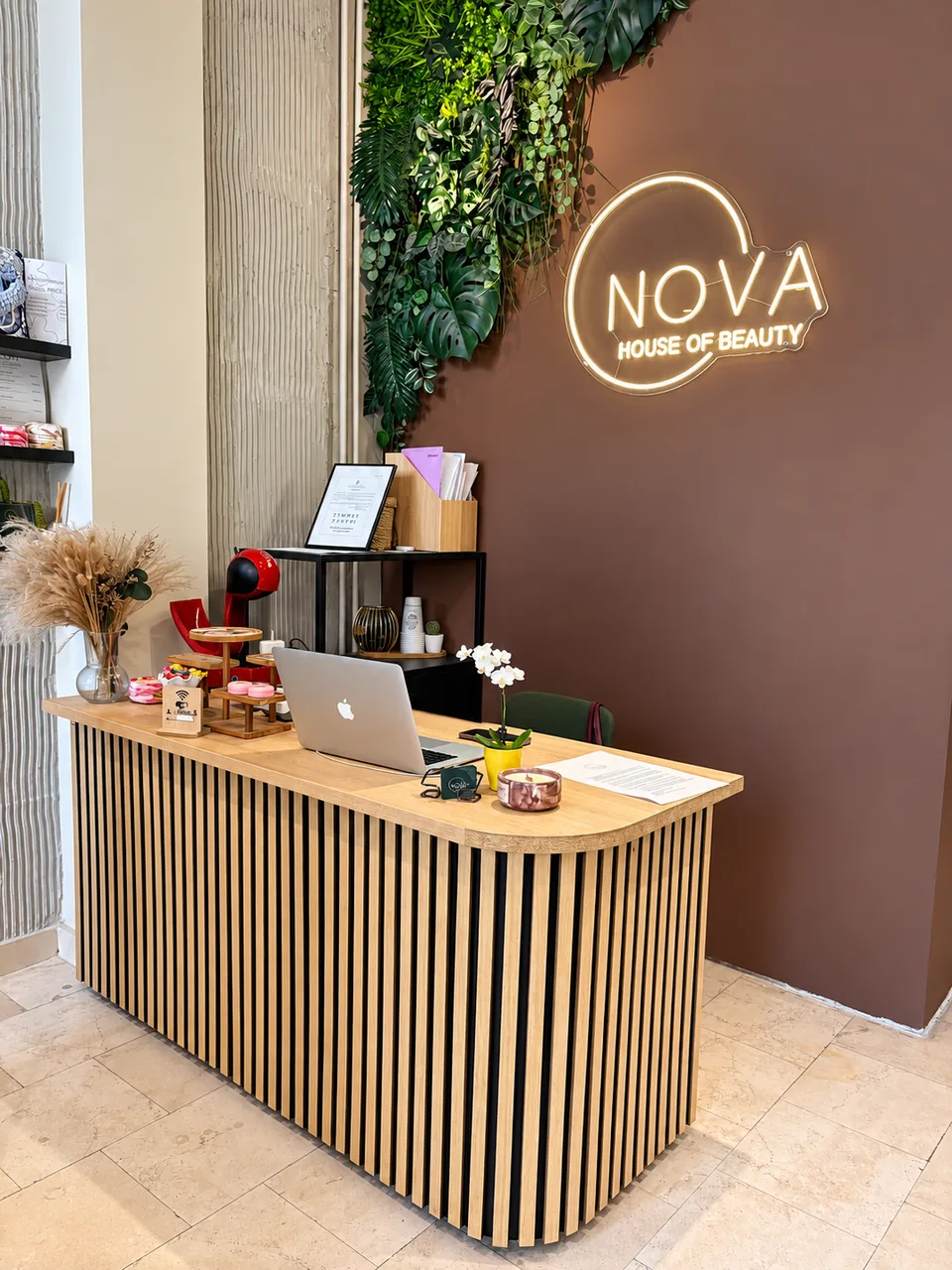 Recepcija salona Nova sa drvenim pultom i logotipom na zidu